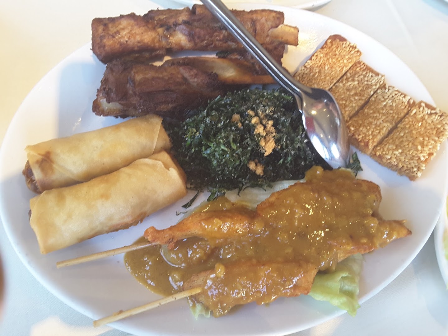 Platter of spring rolls, chicken satay skewers and appetisers
