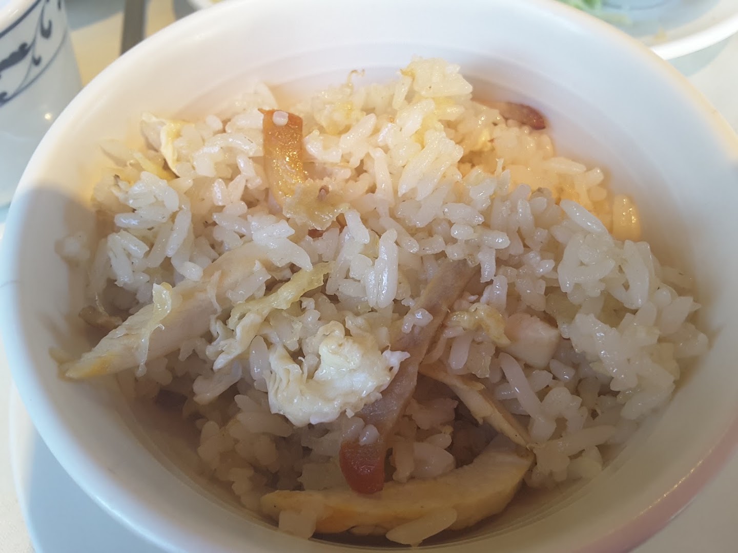 A bowl of fried rice with egg and meat