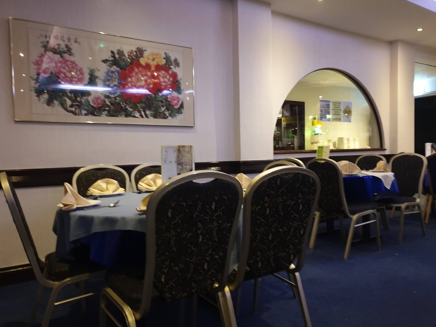 Round tables set with blue cloths and folded napkins