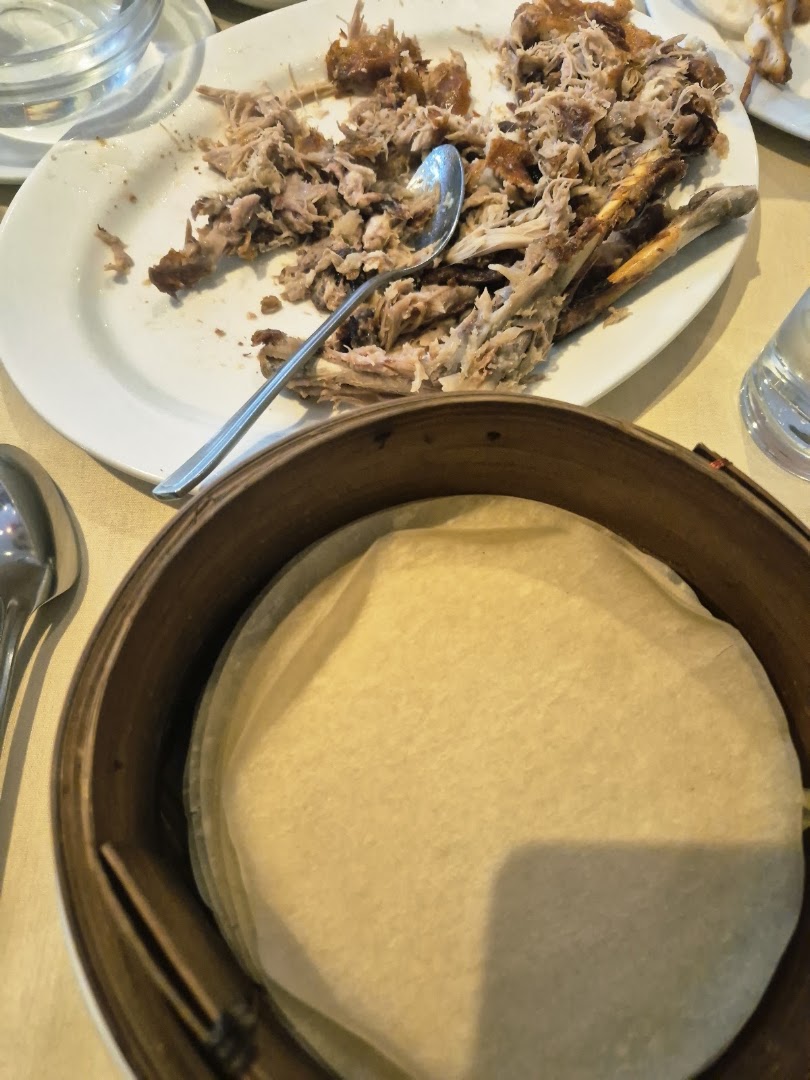 Shredded Peking duck with a bamboo steamer of thin pancakes