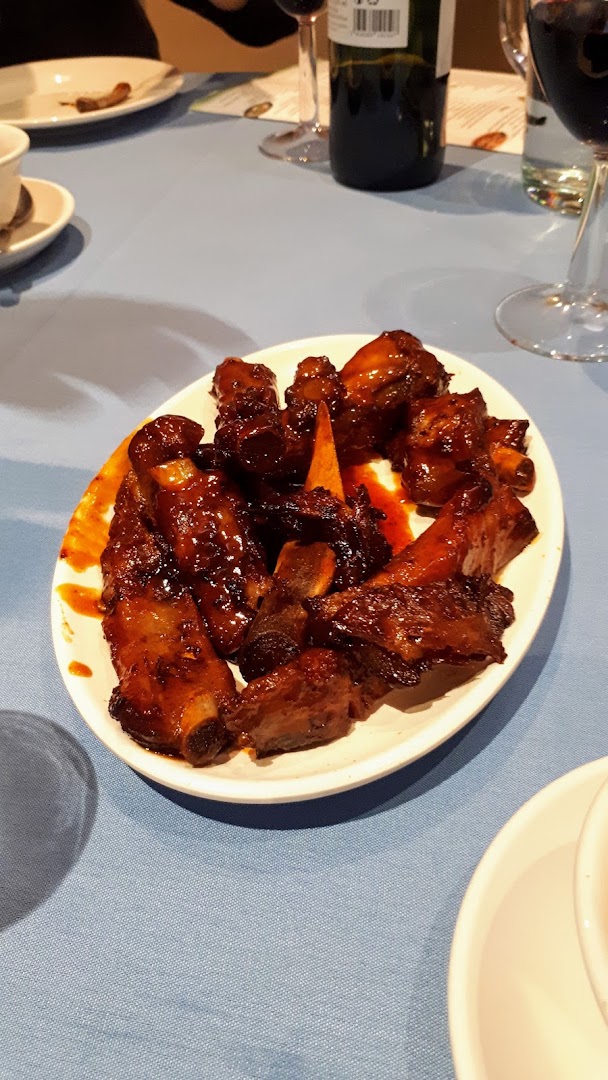 Glossy dark-glazed pork ribs on a white oval plate